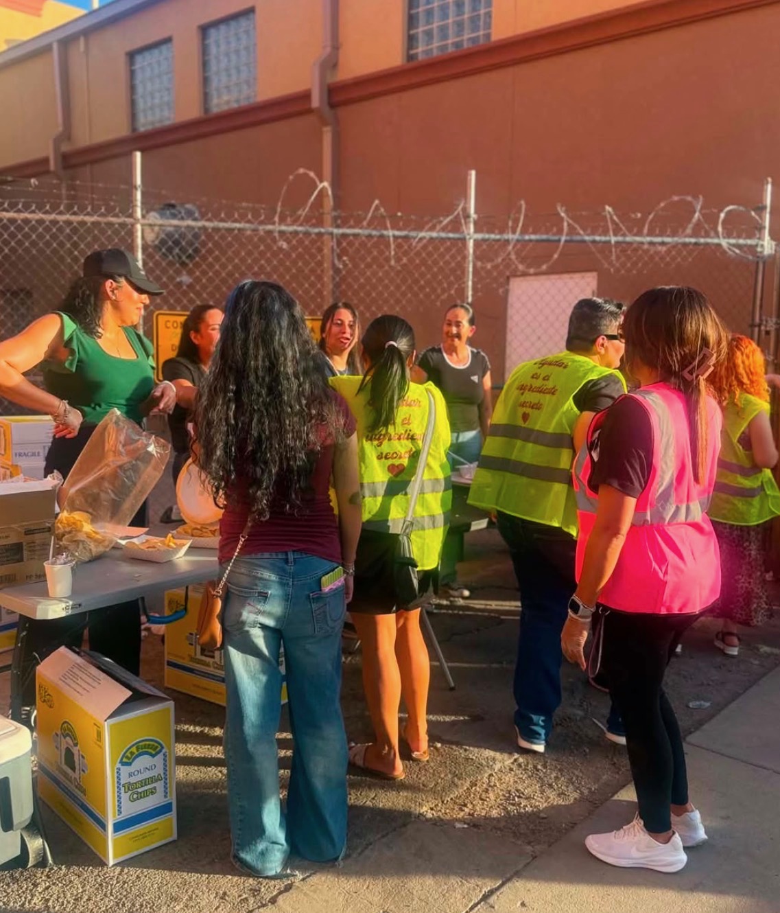 Community members gathering around the food tables at sunset