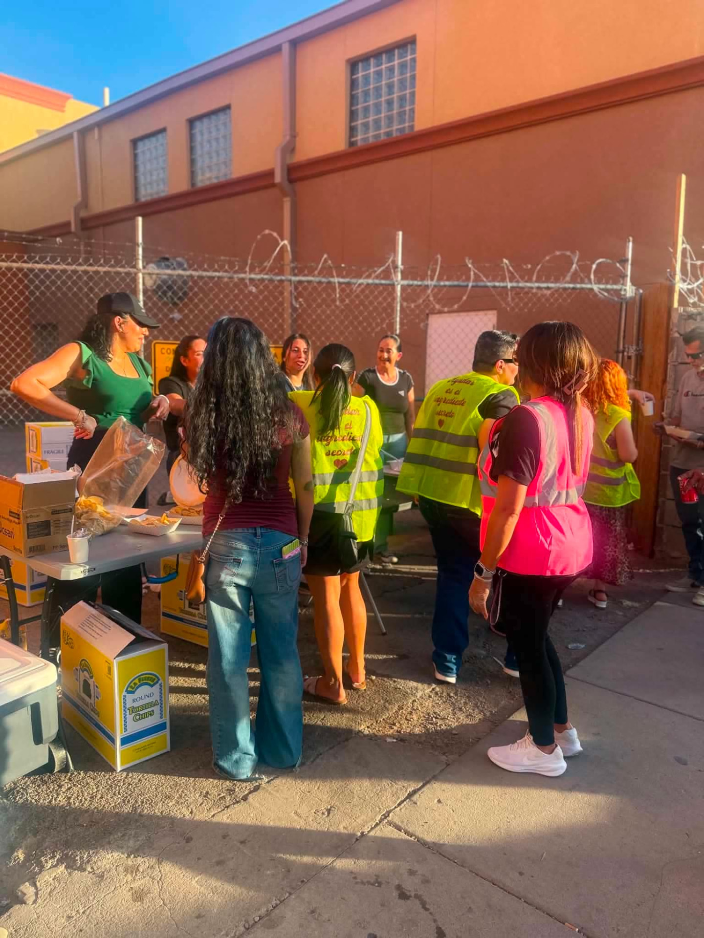 Volunteers and neighbors gathered around the outdoor serving tables