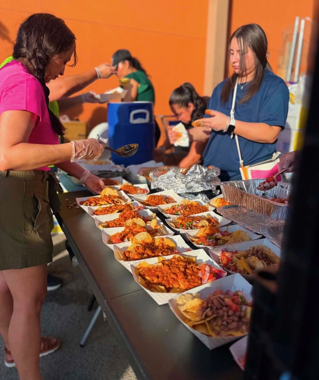 Volunteers plating trays of food at the Thursday serving table